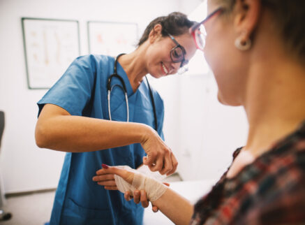 A female doctor bandaging a patients wrist